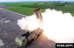Fotografija snimljena 24. avgusta 2019., a objavljena 25. avgusta prikazuje probno ispaljivanje 'novorazvijenog super velikog višecevnog bacača raketa', na nepoznatoj lokaciji u Severnoj Koreji.