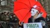 Policemen smile as a man wearing a mask holds a placard reading &quot;Worker but not criminal&quot; during a march of sex workers in Kyiv. (AFP/Serhiy Supinsky)