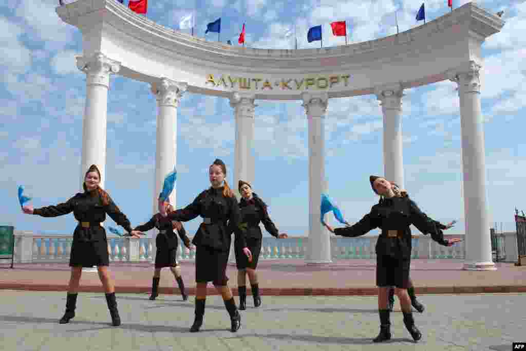 Girls wearing World War II-style Soviet military uniforms dance in the Crimean town of &nbsp;Alushta. (AFP/Yury Lashov)