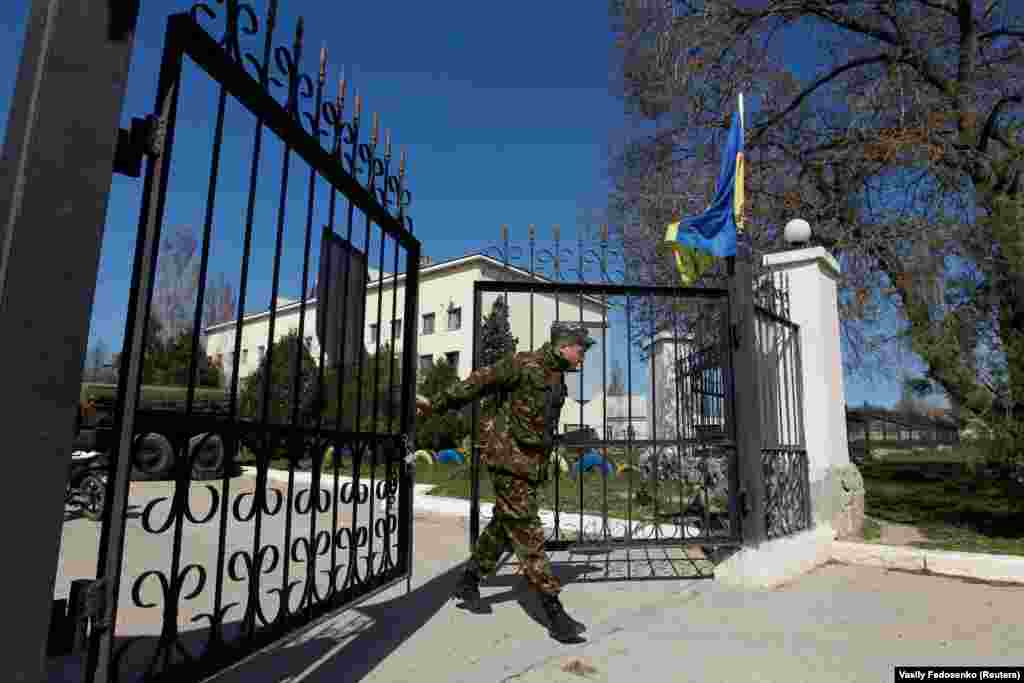 21 марта 2014, Бельбек. Украинский военный закрывает ворота военной части