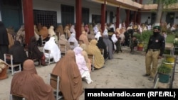 Žene obučene u burke čekaju da dobiju novac od vladinog programa "Hitni gotovinski program Ehsaas" za vrijeme potpunog zatvaranja u provinciji Pashtunkhwa, Pakistan, maj 2020.