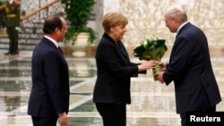 Belarusian President Alyaksandr Lukashenka (right) welcomes German Chancellor Angela Merkel and French President Francois Hollande in Minsk on February 11 for the first day of the Minsk II talks.