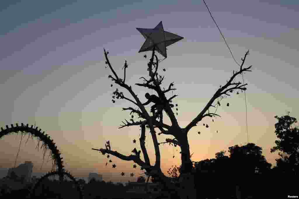 Men decorate a tree with lights ahead of Christmas in a Christian slum in Islamabad, Pakistan. (Reuters/​Faisal Mahmood)