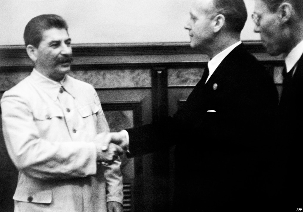 Генеральний секретар ЦК ВКП(б) Йосип Сталін потискає руку міністру закордонних справ нацистської Німеччини Йоахіму фон Ріббентропу після підписання пакту Молотова-Ріббентропа. Москва, 23 серпня 1939 року