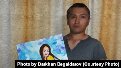 Дархан Бегайдаров өзі салған суретті көрсетіп тұр. Суретішінің жеке архивіндегі фото.