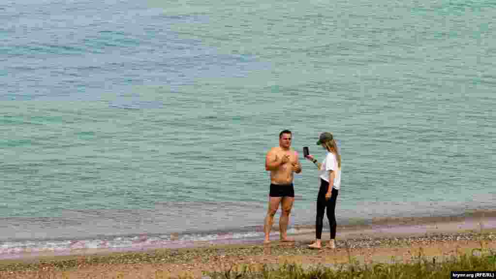 Другая пара на соседнем пляже ограничилась лишь фотосессией на мобильный телефон