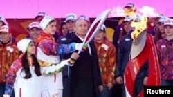Russian President Vladimir Putin (in suit) was joined by national athletes at a ceremony to mark the start of the Sochi 2014 Winter Olympic torch relay in Moscow on October 6.