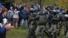 Сілавікі ў масках пагражаюць зброяй мірным пратстоўцам падчас маршу ў Курапаты 1 лістапада 2020