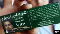 A Pakistasni man holds a matchbox cover in July 2006 announcing a reward for information leading to the capture of suspected senior Al-Qaeda leader Adnan El Shukrijumah.