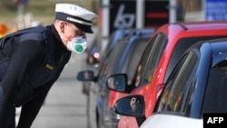 Германски граничен полицай разпитва шофьор на границата с Австрия