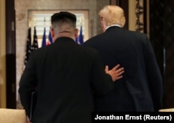 U.S. President Donald Trump (right) and North Korea's leader Kim Jong Un leave after signing documents that acknowledge the progress of the talks and pledge to keep momentum going, after their summit in Singapore on June 12.