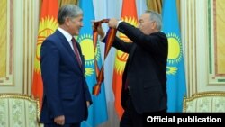 Президент Казахстана Нурсултан Назарбаев вручает орден президенту Кыргызстана Алмазбеку Атамбаеву. Астана, 7 ноября 2014 года. 