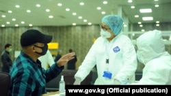 Киргизстанський урядовець перевіряє роботу медиків в аеропорту «Манас», Бішкек, 18 березня 2020 року