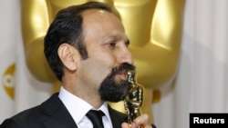 Asghar Farhadi, director of Iranian film "A Separation," kisses his award for best foreign-language film.