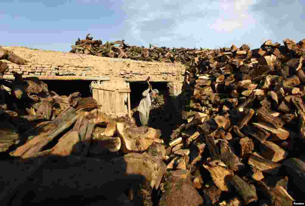 An Afghan man chops wood at his shop in Kabul October 27. (Reuters/Mohammad Ismail)