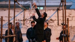 یک مامور جمهوری اسلامی در حال آماده کردن طناب دار برای اعدام یک متهم