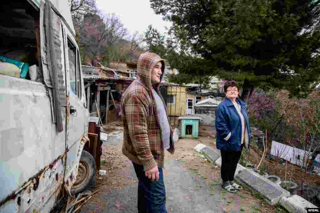 Muedin's brother Murat and their mother outside their home