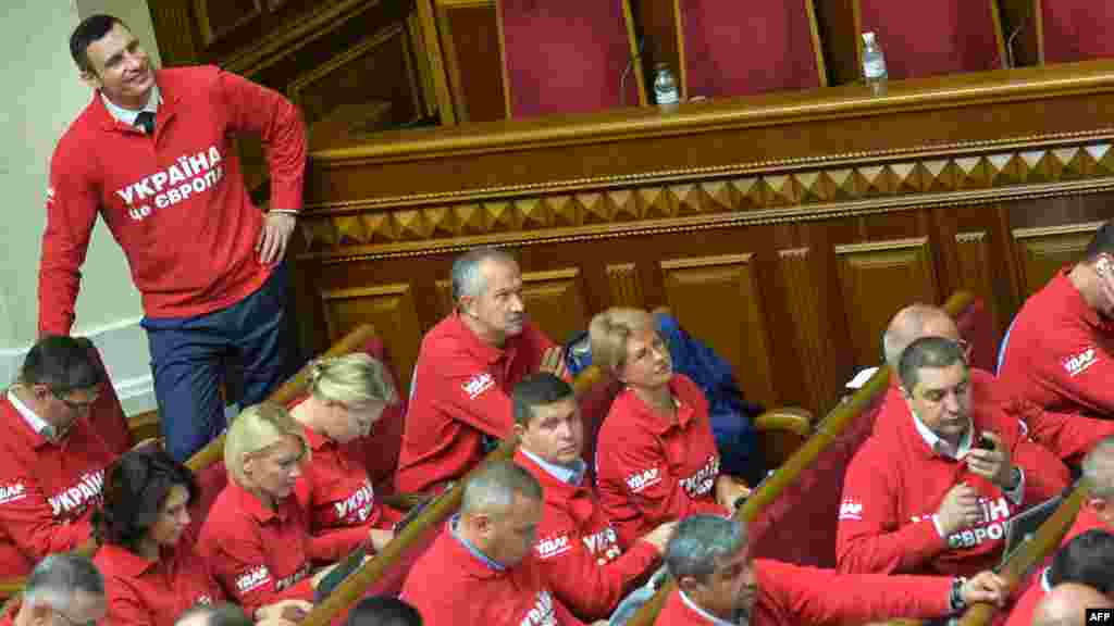 Ukrainian boxer and opposition party leader Vitali Klitschko smiles as he and his deputies wear "Ukraine is Europe" T-shirts during the opening of the new parliamentary session in Kyiv. (AFP/Sergei Supinsky) 