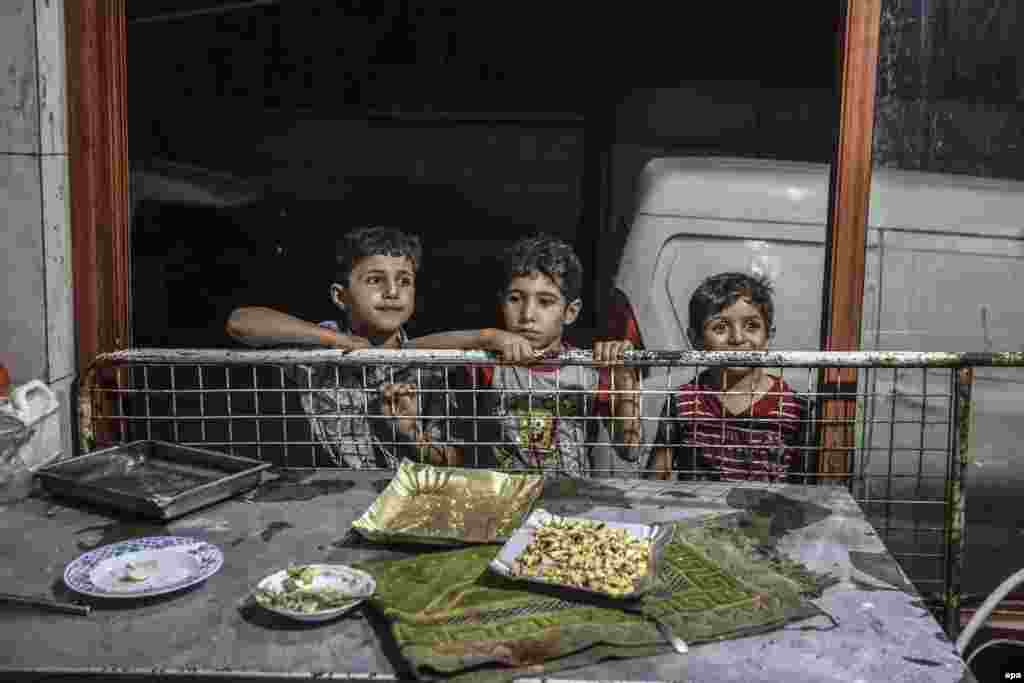 Djemtë sirianë shikojnë një shitës teksa bën akullore në Hamorya, Ghouta, Siri.&nbsp;
