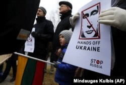 Demonstrators gather outside the Russian Embassy in Vilnius, Lithuania, to protest against Russian intervention in Ukraine in March 2014.