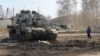 Місцевий житель дивиться на пошкоджений російський танк у місті Тростянець, Сумська область, 22 березня 2022 року