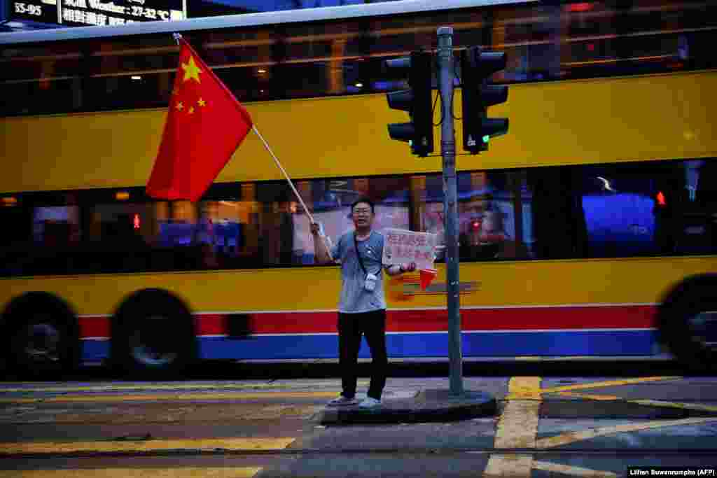 У Ганконгу ў часе пратэстаў праўладны актывіст размахвае кітайскім сьцягам. (AFP/Lillian Suwanrumpha)