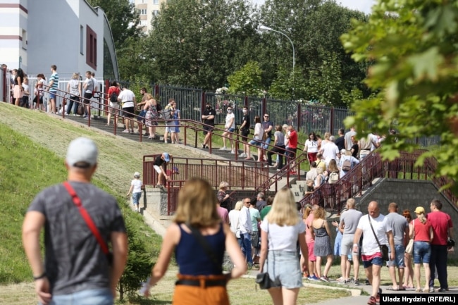 Виборчі стоять в черзі на виборчій дільниці, що розташована в 41-й школі Мінська. 9 серпня 2020 року