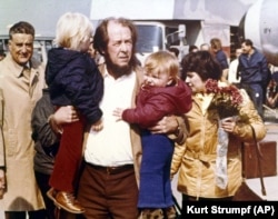 Aleksandr Solzhenitsyn reunites with his sons Yermolai (left) and Ignat, and his wife Natalia (in background) in Zurich, Switzerland, in March 1974, at the beginning of the family's exile from Russia.