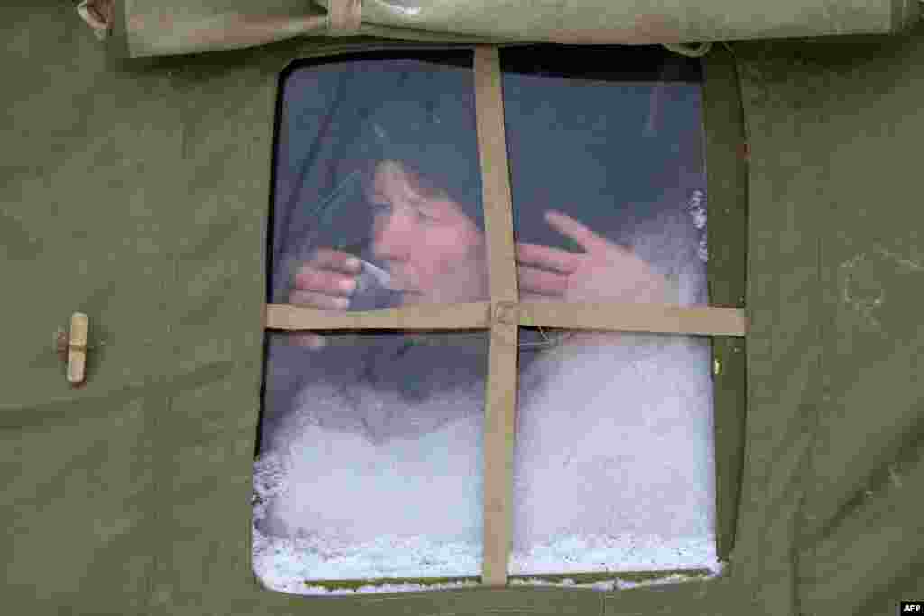 A homeless woman drinks free tea in a tent set by Ukraine's Emergencies Ministry in the city of Donetsk.