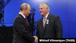 Володимир Путін та Рекс Тіллерсон тиснуть одне одному руки на енергетичному саміті. Санкт-Петербург, червень 2013 року
