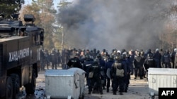 Bulgarian riot police stand by during clashes in the migrant reception center at Harmanli on November 24 after 1,500 migrants started rioting and setting fires at the country's largest refugee camp. 