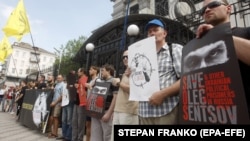 Activists holds posters with images of Ukrainian film director Oleh Sentsov during a rally in support of Sentsov and other Ukrainian political prisoners jailed in Russia in front of the Russian Embassy in Kyiv on June 13.