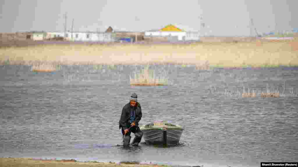 Местный рыбак связывает лодку на берегу Аральского моря, село Каратерен.