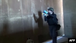 A TV grab shows an inspector from the Organization for the Prohibition of Chemical Weapons (OPCW) at work at an undisclosed location in Syria.