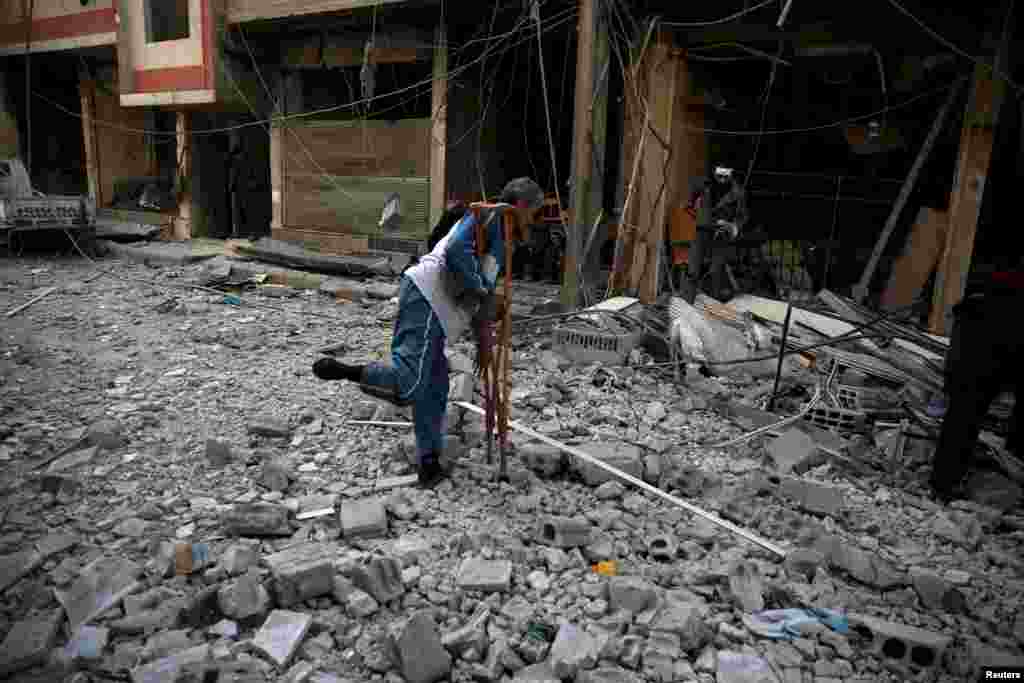 Men search for belongings at a site hit by missiles in the Douma neighborhood of Damascus, Syria. (Reuters/Bassam Khabieh)