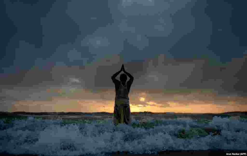 An Indian Hindu devotee prays to the sun god standing on the shores of the Bay of Bengal at marina beach during the Chhath Puja festival in Chennai on October 27. (AFP/Arun Sankar)