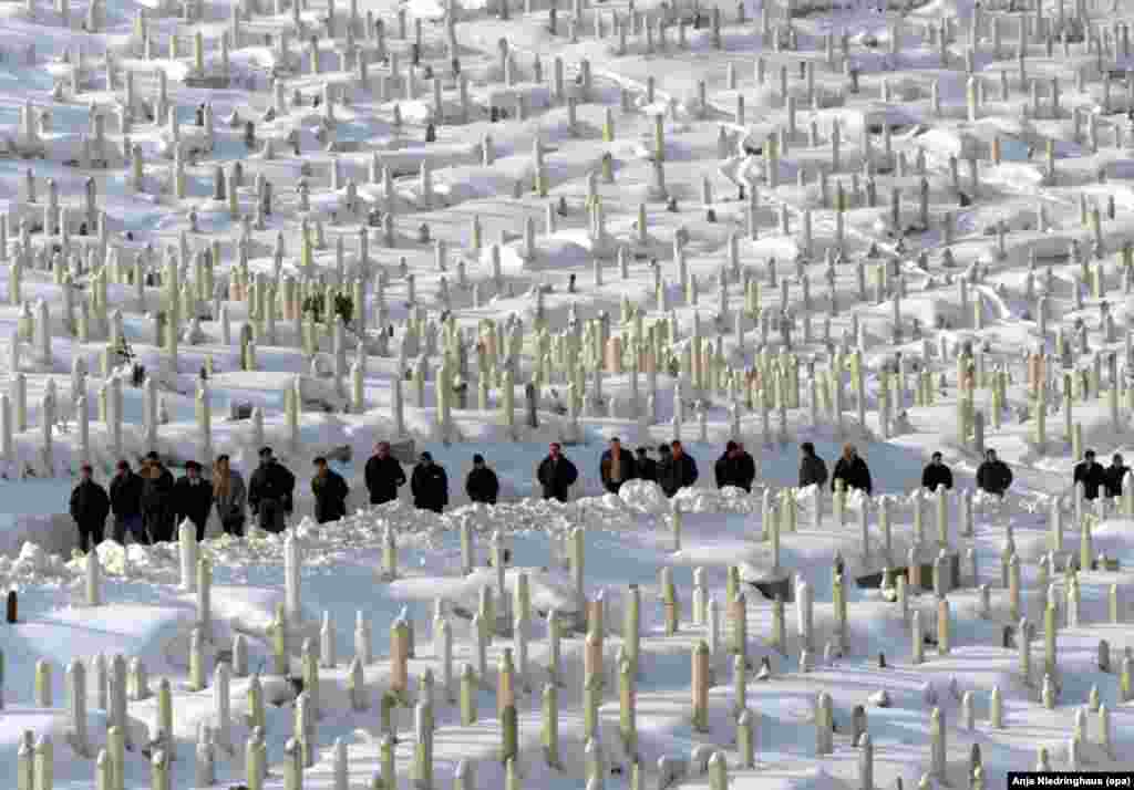 Sarajevans cross the Bare cemetery outside the Bosnian capital on January 27, 2000.