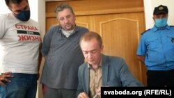 Яўген Васількоў (у шэрай кашулі) з адвакатам у судзе