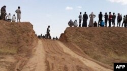 Фотография, на которой предположительно запечатлены боевики "Исламского государства Ирака и Леванта" у недавно проложенной дороги через иракско-сирийскую границу, 10 июня 2014 года. 