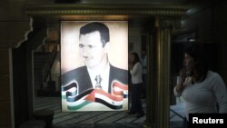 Президент Башар Асадтың суретіне қарап тұрған адам. Дамаск, 6 тамыз 2012 жыл.