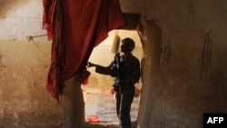 An Afghan National Army soldier walks through the court house in Farah province a day after the April 3 Taliban attack. 