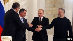 Ռուսաստան – Նախագահ Վլադիմիր Պուտինը, Ղրիմի վարչապետ Սերգեյ Ակսյոնովը (առջևում ձախից), Ղրիմի խորհրդարանի խոսնակ Վլադիմիր Կոնստանտինովը (ձախից հետևում) և Սևաստոպոլի քաղաքապետ Ալեկսեյ Չալիյը Կրեմլում փաստաթղթերի ստորագրման արարողությունից հետո, Մոսկվա, 18 մարտի, 2014թ․