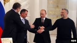 President Vladimir Putin (2nd R), Crimea's Prime Minister Sergei Aksyonov (front L), Crimean parliamentary speaker Vladimir Konstantinov (back L) and Sevastopol Mayor Aleksei Chaliy shake hands after a signing ceremony at the Kremlin in Moscow.