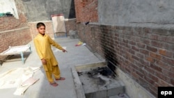 A local resident shows the place where Zeenat Rafiq was allegedly burnt alive by her mother in the eastern Pakistani city of Lahore on June 8.