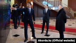 Президент Казахстана Нурсултан Назарбаев (справа) и премьер-министр Бакытжан Сагинтаев (в центре) смотрят на цифровую панель, которую демонстрирует вице-премьер Аскар Жумагалиев. Астана, 30 января 2019 года.