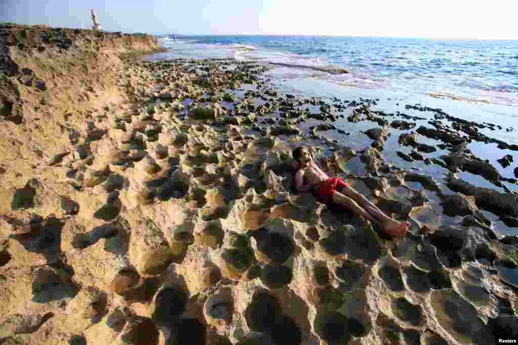 A man enjoys the beach on a tiny island in Sidon, southern Lebanon. (Reuters/Ali Hashisho)