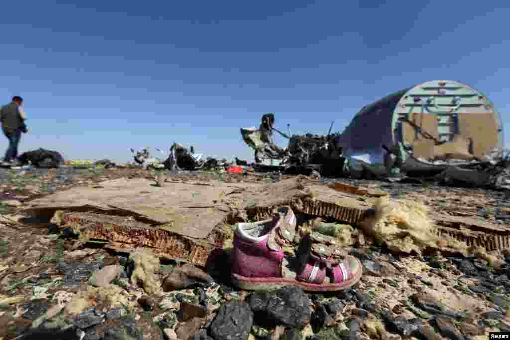 A child&#39;s shoe is seen in front of debris from a Russian airliner that crashed late on October 31 in Egypt&#39;s Sinai region. (Reuters/Mohamed Abd El Ghany)