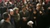 Ikballe Huduti-Berisha (in green head scarf) stands next to former Iranian President Mahmud Ahmadinehad in an undated photo.