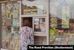 Женщина покупает газету в Минске