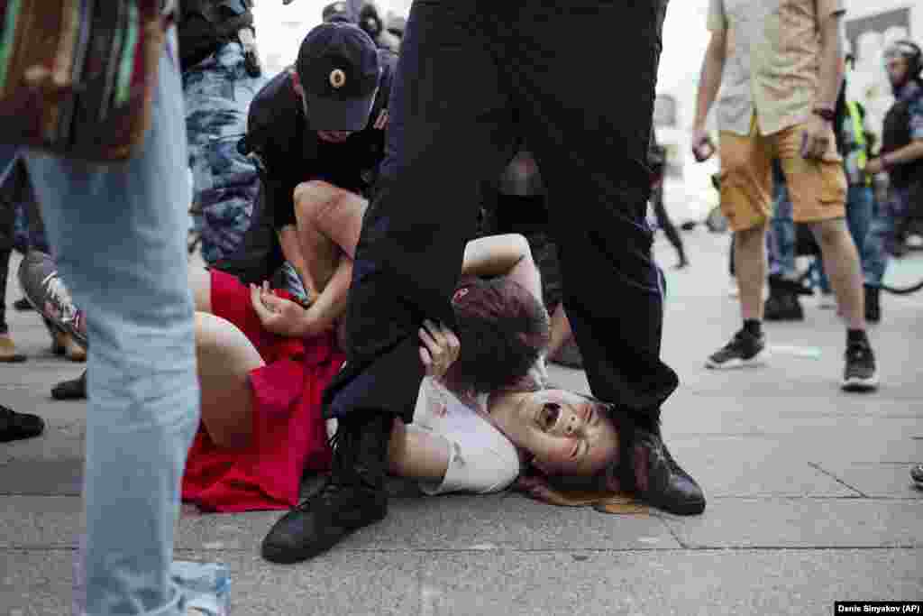 Inga Kudracheva screams as her boyfriend Boris Kantorovich lies atop her while police try to detain him during an anti-government protest in Moscow on July 27.&nbsp;(AP Photo/Denis Sinyakov)